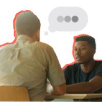 Man and young man sitting across from each other talking